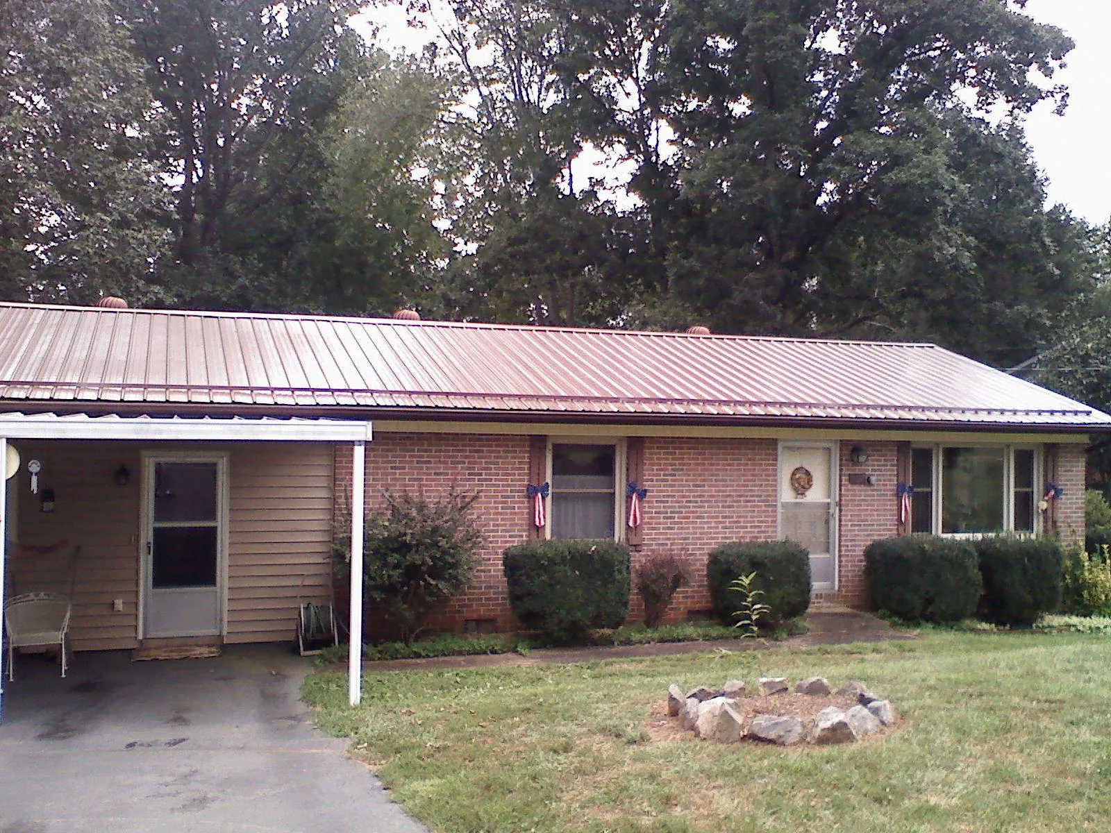 Bronze metal roof and carport on a brick ranch home — Roof Repair work by our crew in Rossiter
